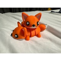 Turuncu, sevimli yüz ifadeli ve eklemli gövdeli tilki figürü.